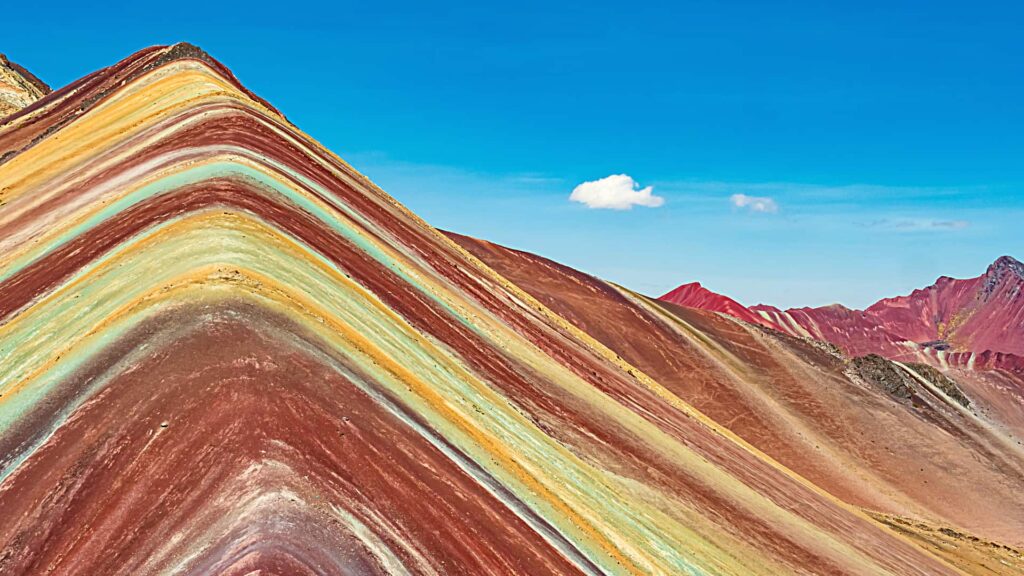 Hikers enjoying breathtaking views from the summit of Pallay Punchu Mountain.